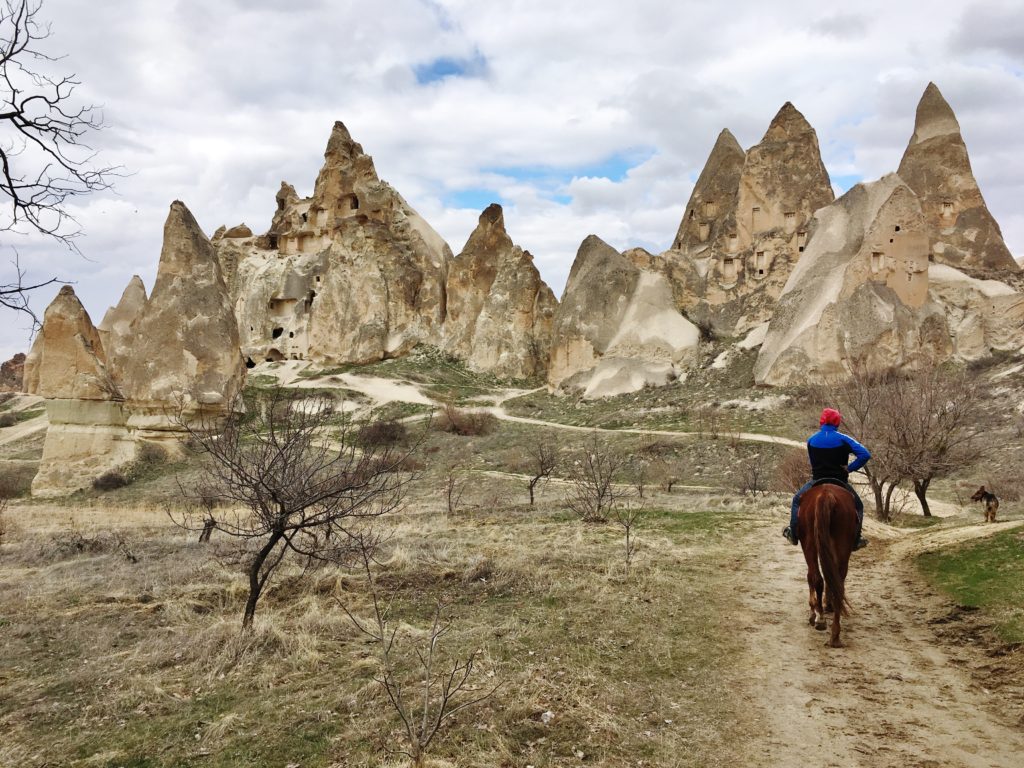 Riding on horseback through the landscape of Cappadocia, Turkey