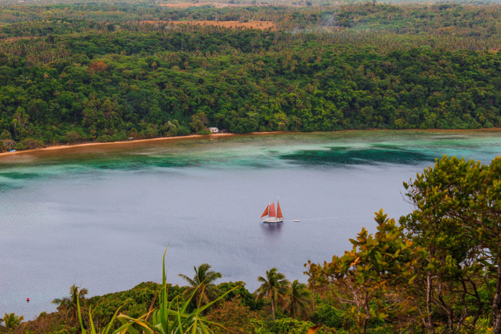 A boat sailing through the water channels around Vava'u, Tonga