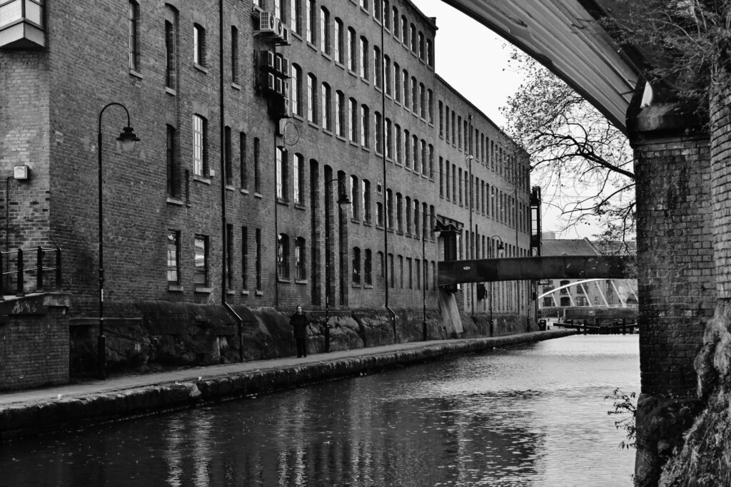 Black and white image of an industrial building next to a canal, one of the best photo spots in Manchester
