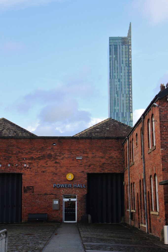 A tall skyscraper behind red brick buildings