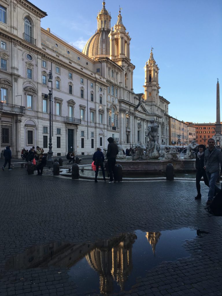 Piazza Navona, with a building reflected in a puddle, Rome, Italy