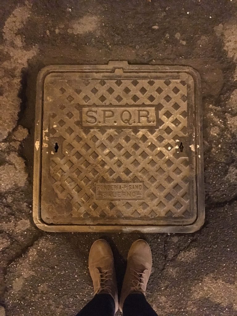 A street grate with the famous ancient Roman letters SPQR, seen in Rome, Italy