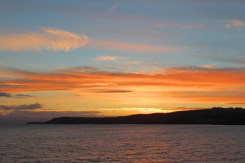 Orange clouds below a blue sky over Lake Taupo