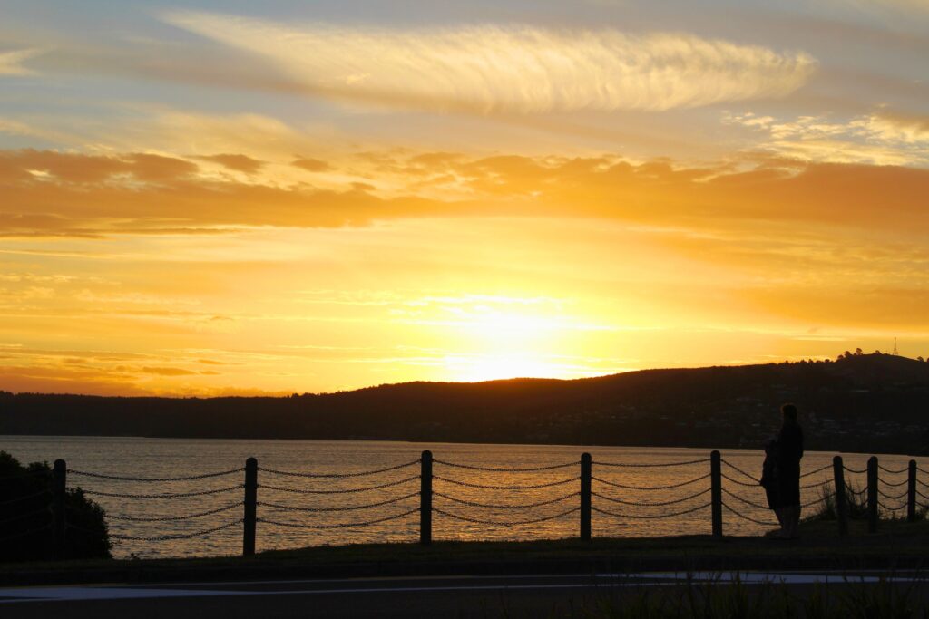 Sunset over Lake Taupo, silhouetted people in front