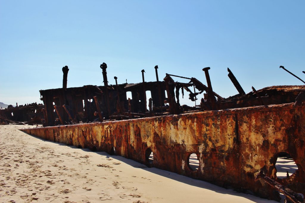 The rusting remains of the SS Maheno is being buried by the sand on Fraser Island, Australia