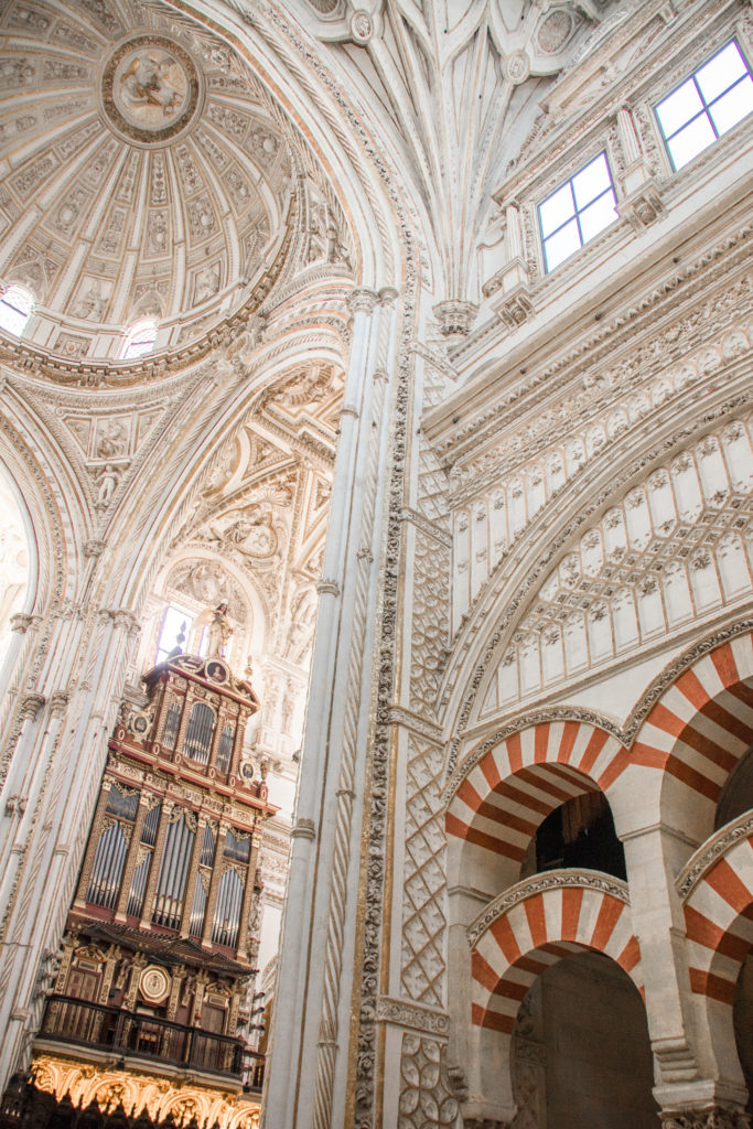 The stripes of the old mosque meet the white dome of the newer cathedral in Córdoba's Mezquita, Spain