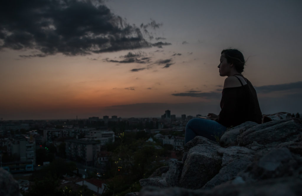 Sitting above the city of Plovdiv as the sun goes down, enjoying a moment of travelling solo