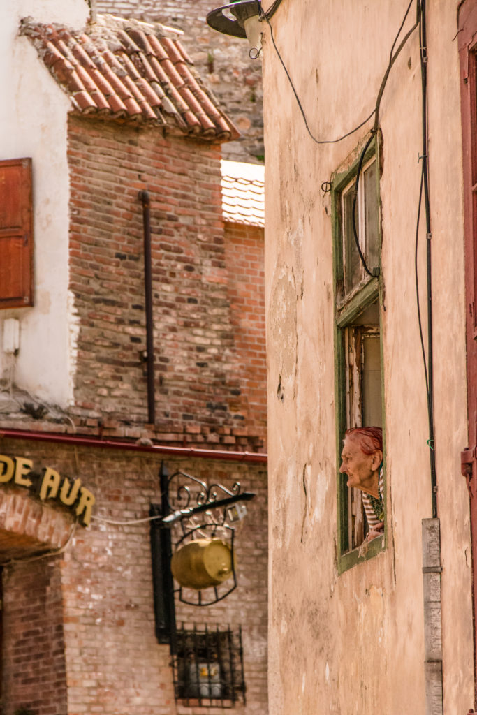 Old lady looking out her window in Sibiu, Romania