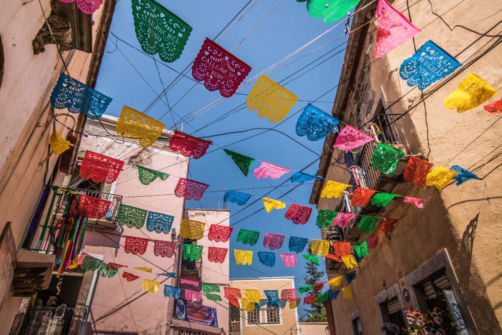 Brightly coloured flags stretch across the streets in Guanajuato, Mexico