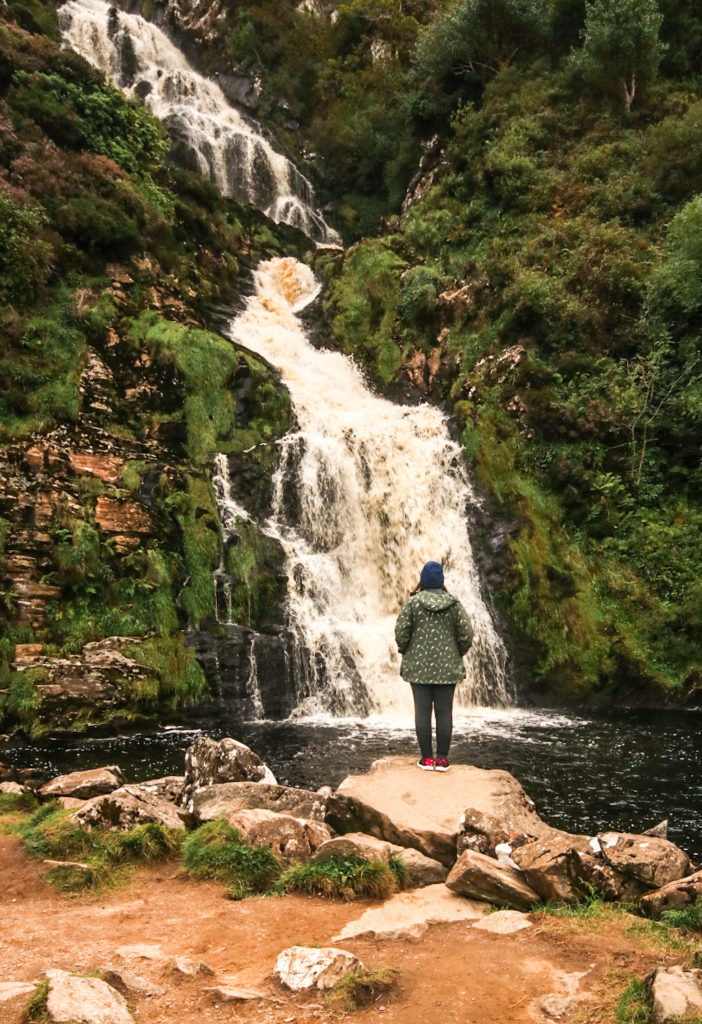 Standing in front of Assaranca Waterfall, a lesser-known Donegal roadtrip destination