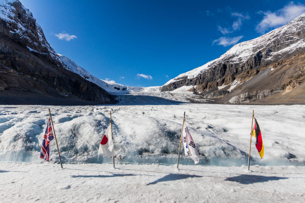 Country flags dot the surface of the Athabasca Glacier, on of the top Banff Bucket List attractions that definitely should't be missed during a visit.