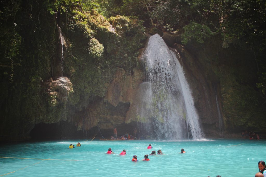 Swimmers in the turquoise waters of Kawasan Falls on the island of Cebu