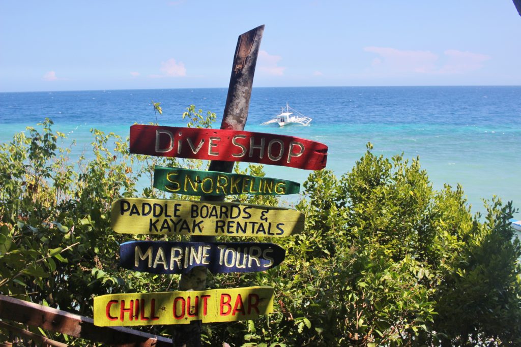 Coloured signs in front of the ocean at the Bohol Bee Farm
