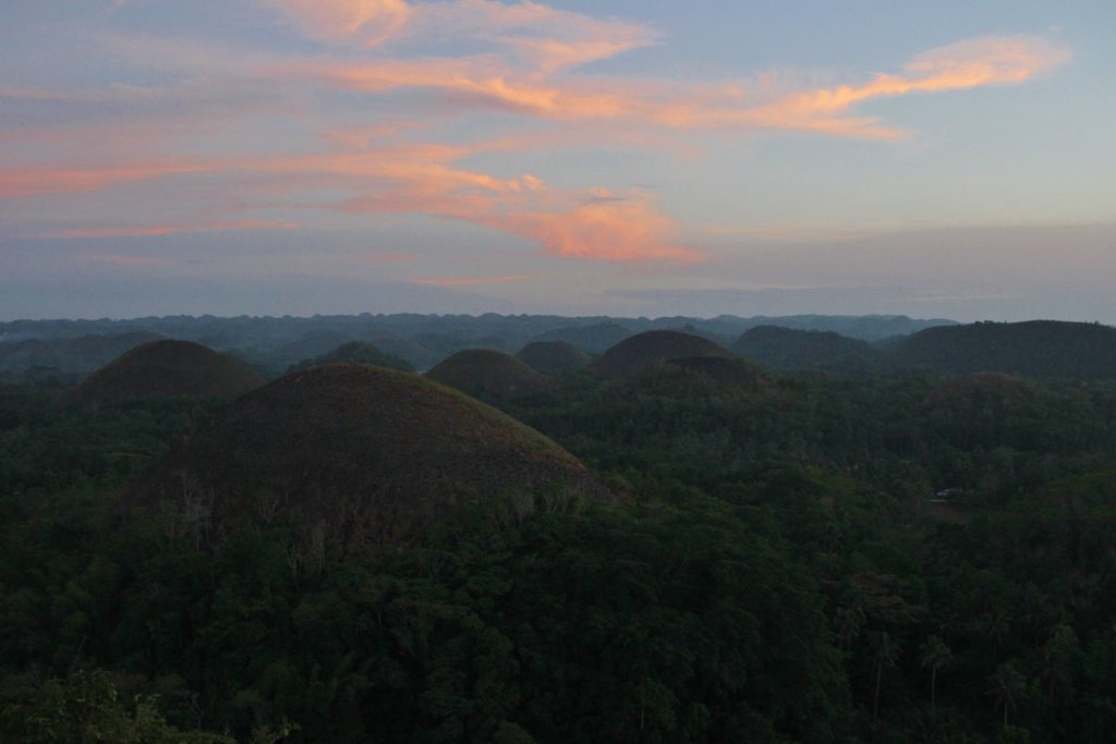 A purple and pink sunset over the Chocolate Hills in Bohol