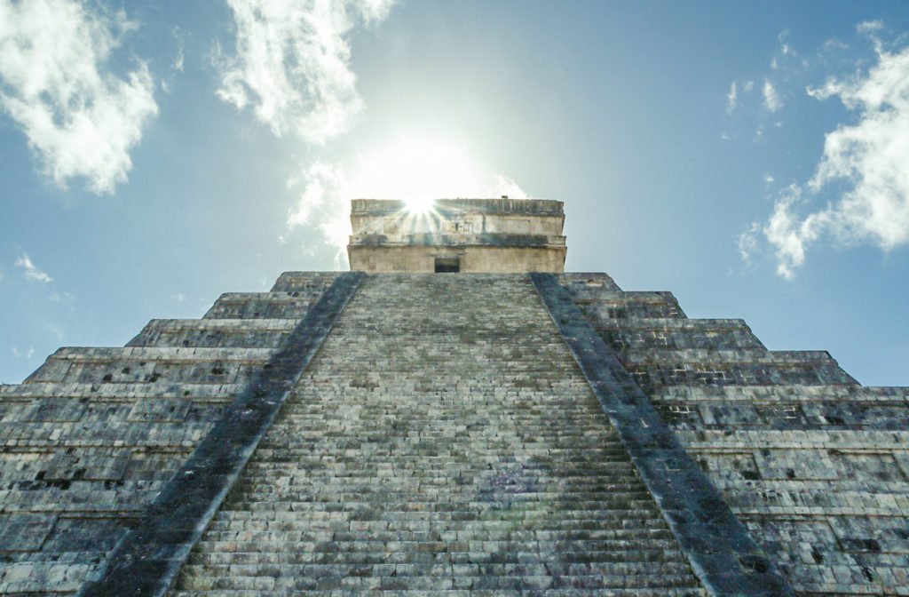 A sunbeam comes from behind the top of El Castillo, the pyramid at Chichen Itza