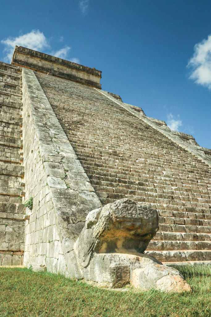 Stone snake head at the bottom of the staircase up El Castillo, at Chichen Itza