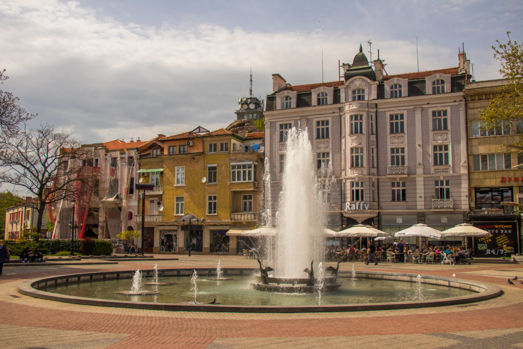 A large fountain in front of tall, pretty buildings in the centre of Plovdiv, Bulgaria