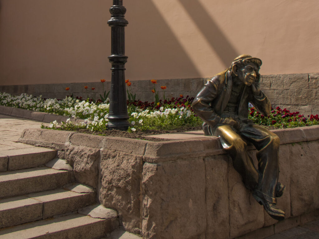 The bronze statue of Milyo the Crazy sitting on the main pedestrian street of Plovdiv, Bulgaria