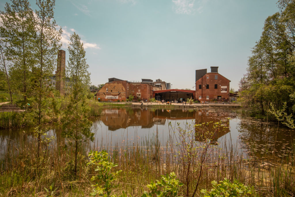 Red brick buildings by a small lake at the Evergreen Brickworks near Toronto