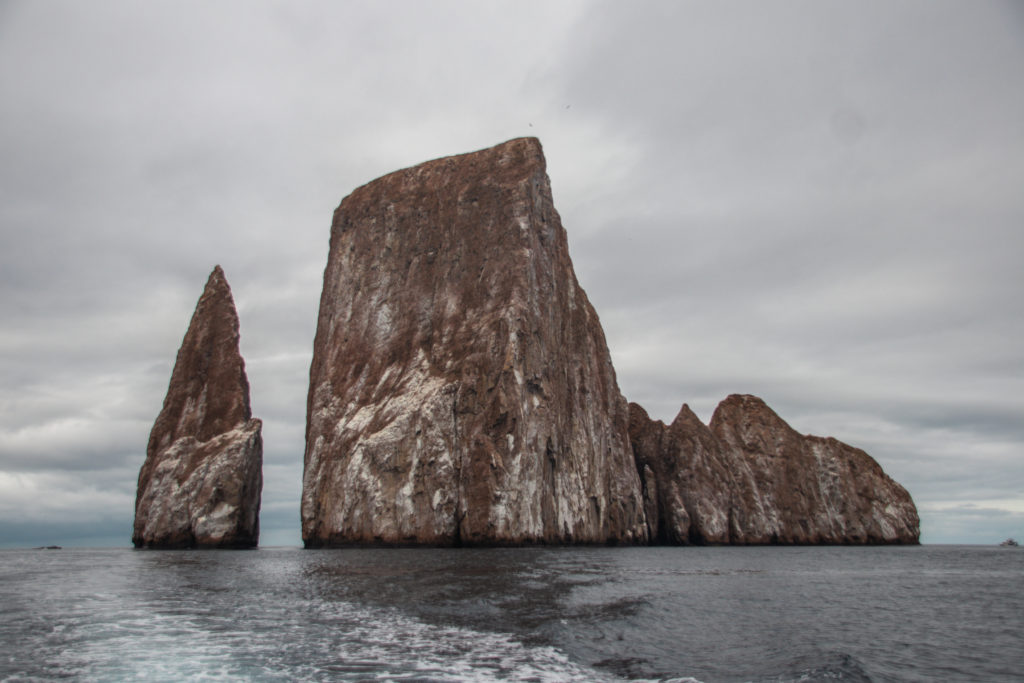 Kicker Rock, a large rock formation surrounded by water, a pointed pinnacle separate