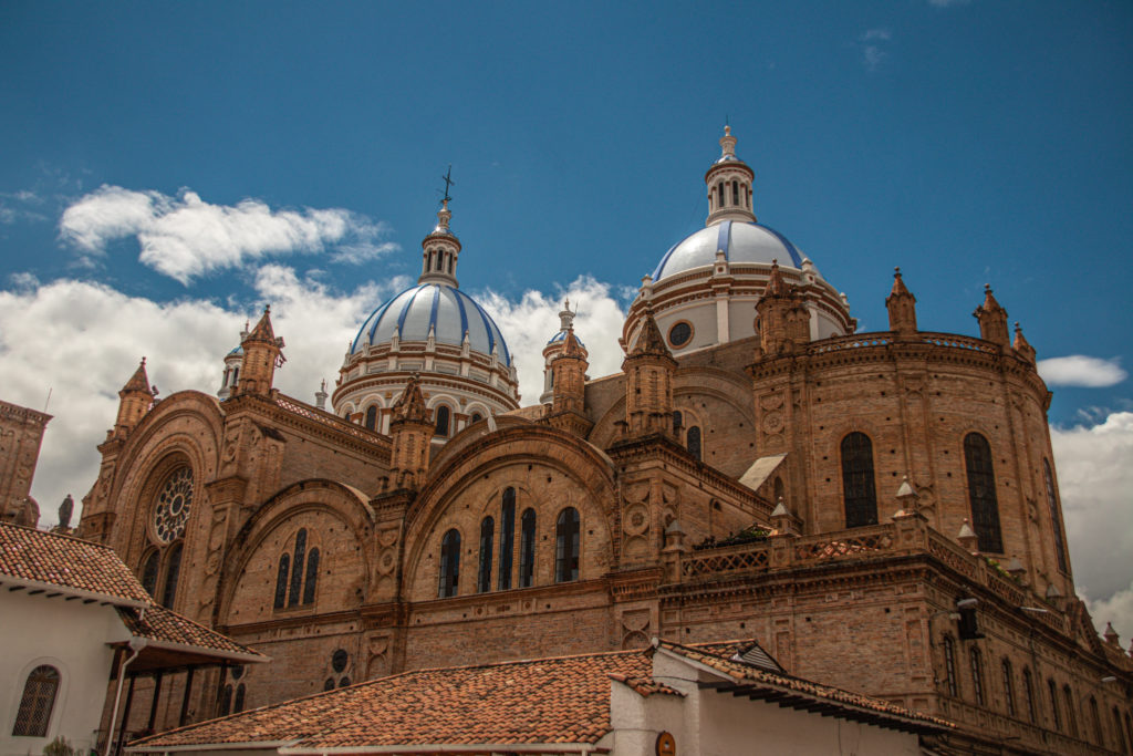 Red brick and blue domes of the Cuenca Cathedral, a great stop in any Ecuador itinerary