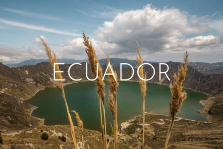 A green lake inside a large volcano crater, stalks of dry grass in the foreground, overlaid with the word Ecuador