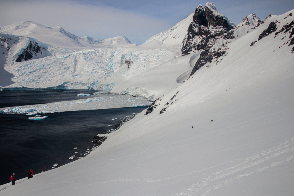Snow-covered hills in a semi-circular bay filled with ice floes on the Antarctic Peninsula