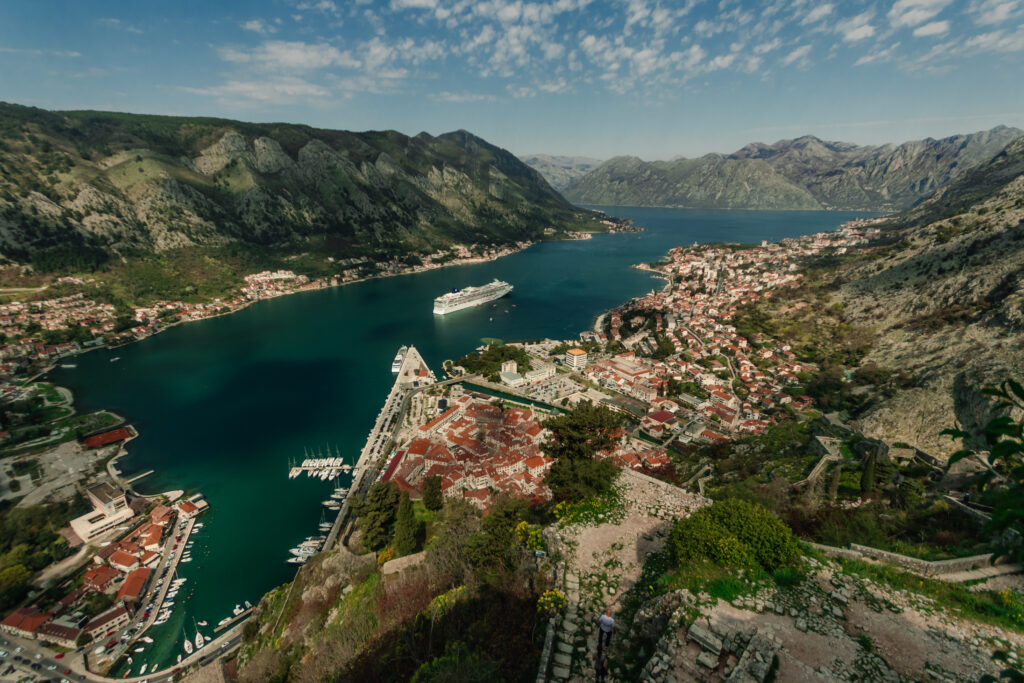 Looking down over the town of Kotor, with a large cruise ship in the river, surrounded by mountains