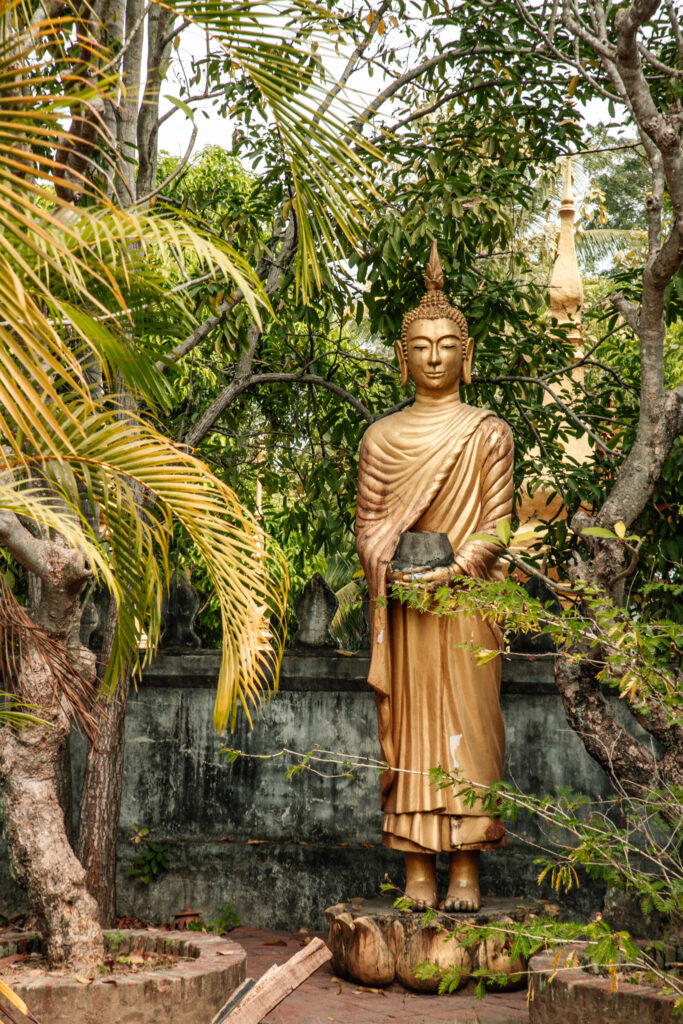 A golden statue surrounded by green palm fronds