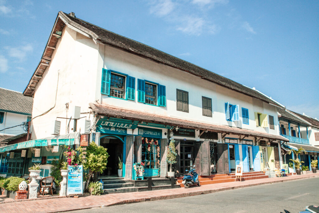White and blue building a shop on the lower floor on the main street of Luang Prabang