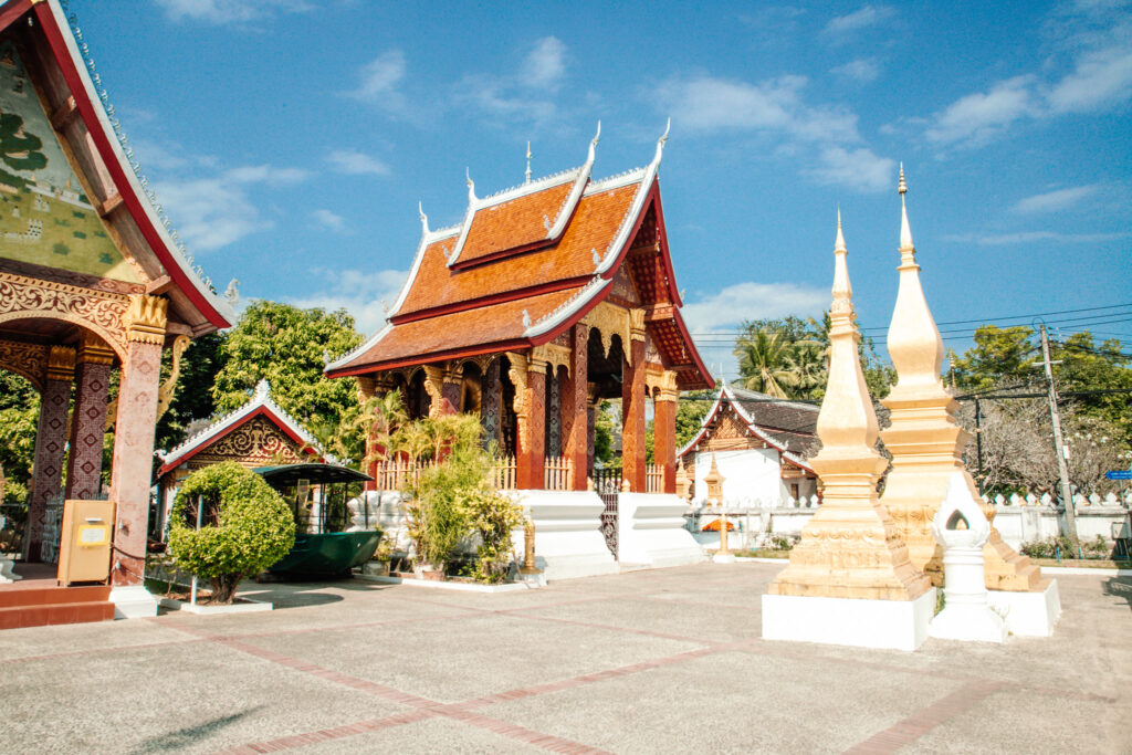 An orange temple building in a wide courtyard