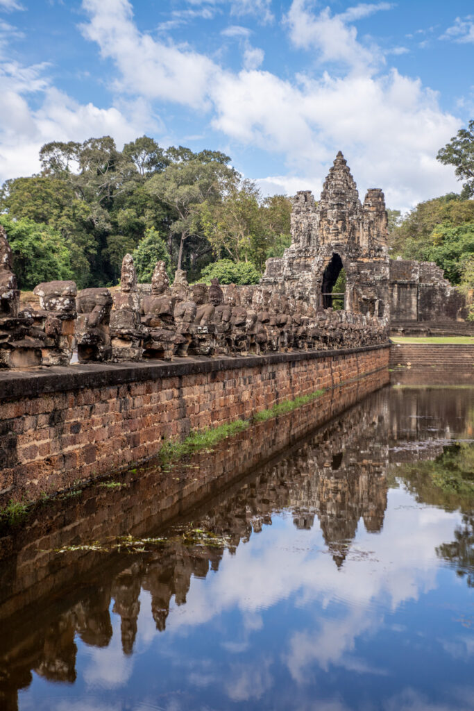 An ornate bridge and temple ruins reflected in water