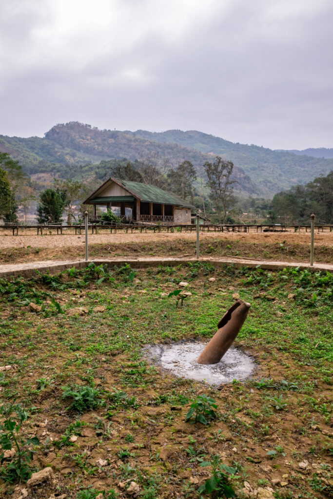 An unexploded bomb sticking out of the ground in an empty rice field