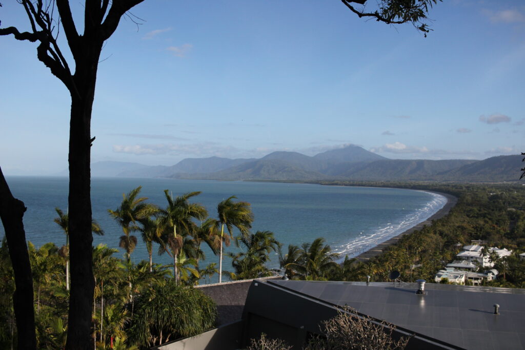View over the ocean, a distant beach and mountains on the horizon