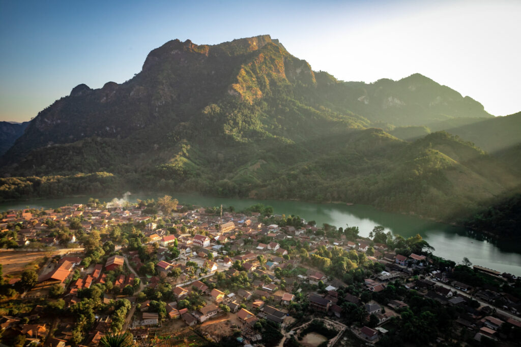 Sun beams from behind mountains shine on Nong Khiaw, a must-add place to any Laos itinerary